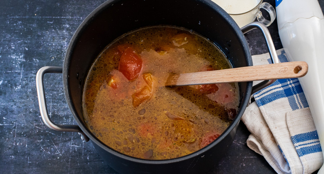 För över tomater och vitlök till en grytan och tillsätt lite vatten och buljong. Koka några minuter. 