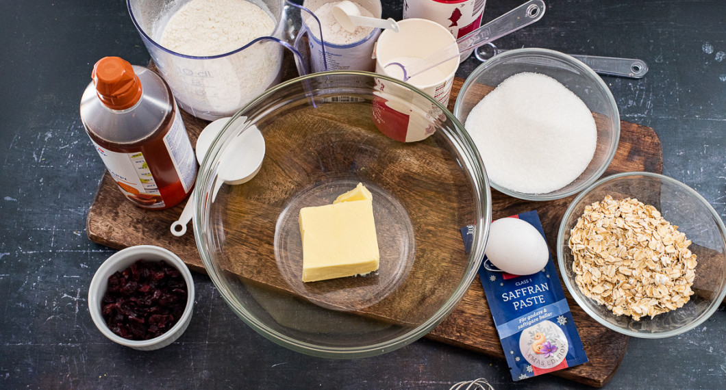 Ingredienser till saffranskakorna: tranbär, sirap, vetemjöl, smör, vaniljsocker, bakpulver, salt, strösocker, ägg, saffranspaste och havregryn. 