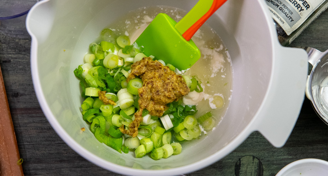 Tillsätt strimlad salladslök samt senap. Rör om. Spara ev. lite salladslök till servering. 