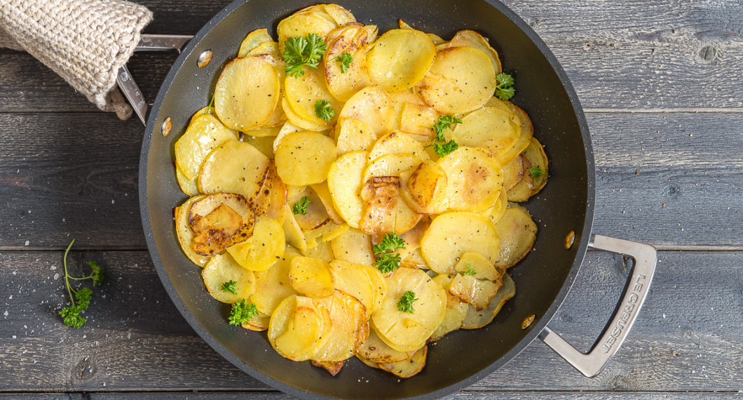 Skivad råstekt potatis i panna till oxfilé provencale. 