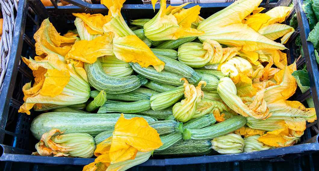 Små zucchinis med blommor till salu på torget