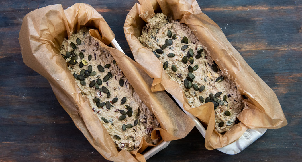 Fördela degen i avlånga brödformar klädda med bakplåtspapper. Toppa med pumpafrön. 