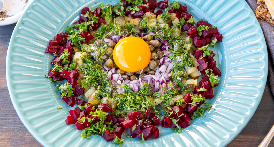 Lägg på hackad persilja på rödbetorna. Lägg äggulan i mitten. Dra över några varv med pepparkvarnen. 