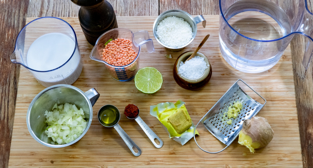 Ingredienser till soppan - kokosmjölk, hackad lök, röda linser, olja, röd currypasta, lime, kokosflingor, grönsaksbuljong, färsk ingefära, vatten, svartpeppar och flingsalt. 