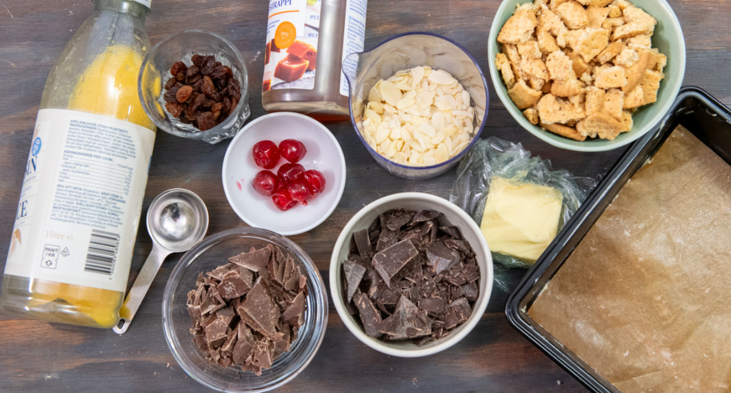 Till fyllningen av tiffin behöver du apelsinjuice, russin, cocktailbär, sirap, ljus choklad, mörk choklad, flagad mandel, smör och digestivekex. 