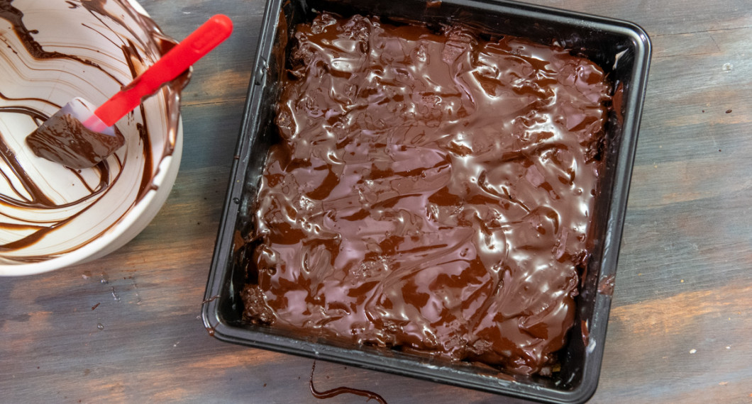 Bred chokladglasyren över fyllningen i ett jämnt lager. 