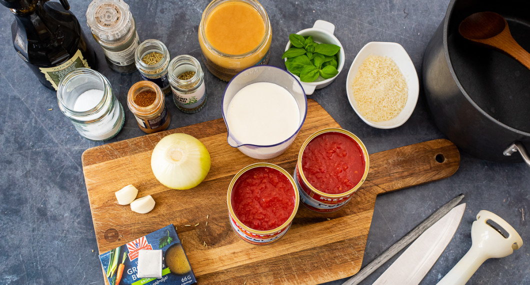 Ingredienser till tomatsoppan: krossade tomater, lök, vitlök, grönsaksbuljong, salt, olivolja, svartpeppar, cayennepeppar, oregano, rosmarin, honung, grädde, basilika och riven parmesan.  