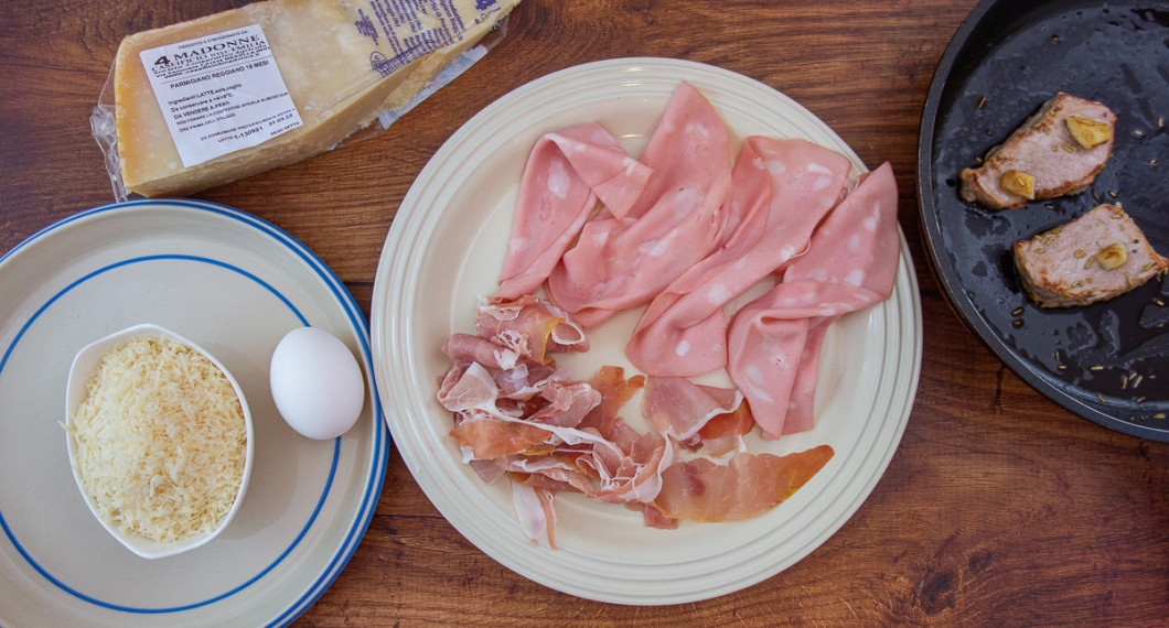 Till köttfyllningen behöver du riven parmesan, mortadella, prosciutto och stekt fläskkotlett med vitlök och rosmarin. 