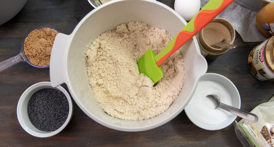 Mät upp mandelmjöl i en bunke. Smörj och bröa en rund springform med smör och vallmofrön. Kläm gärna fast ett bakplåtspapper i botten. 