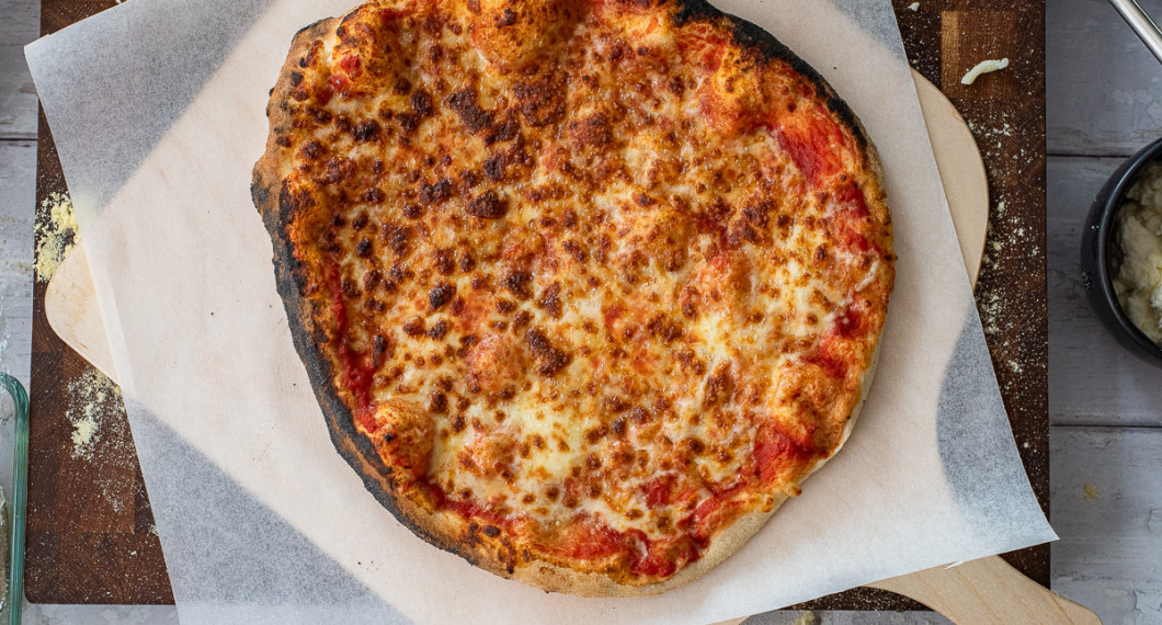 Efter grunden till pizzan är gräddad kan den toppas med grönt och pesto. 