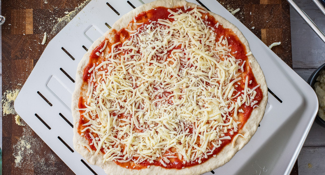 Bred på tomatsås samt ett lager riven mozzarella. 