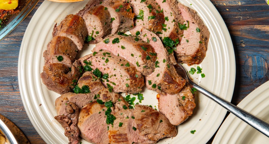Älgfilén skärs upp snett mot köttfibrerna med en vass kniv och serveras på fat eller tallrik.