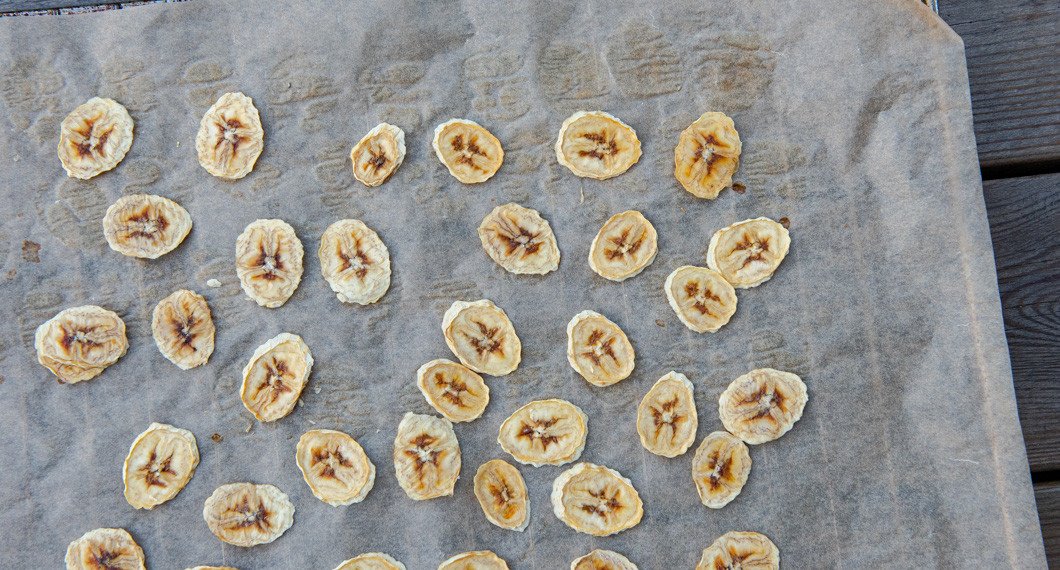Bananchipsen vänds efter några timmar i ugnen. 