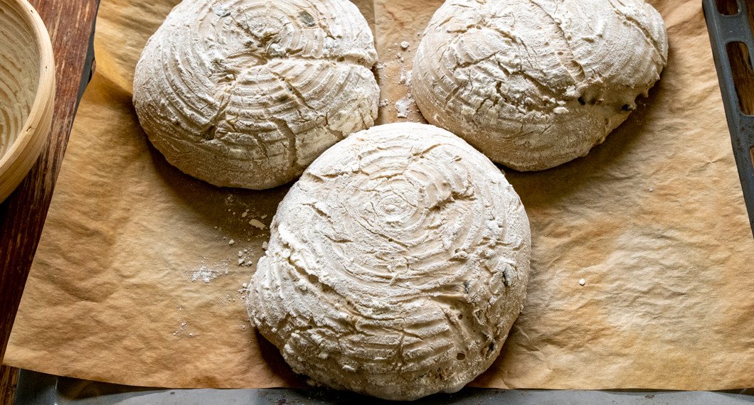 De jästa bröden stjälps upp ur formarna redo att gräddas i ugnen. 