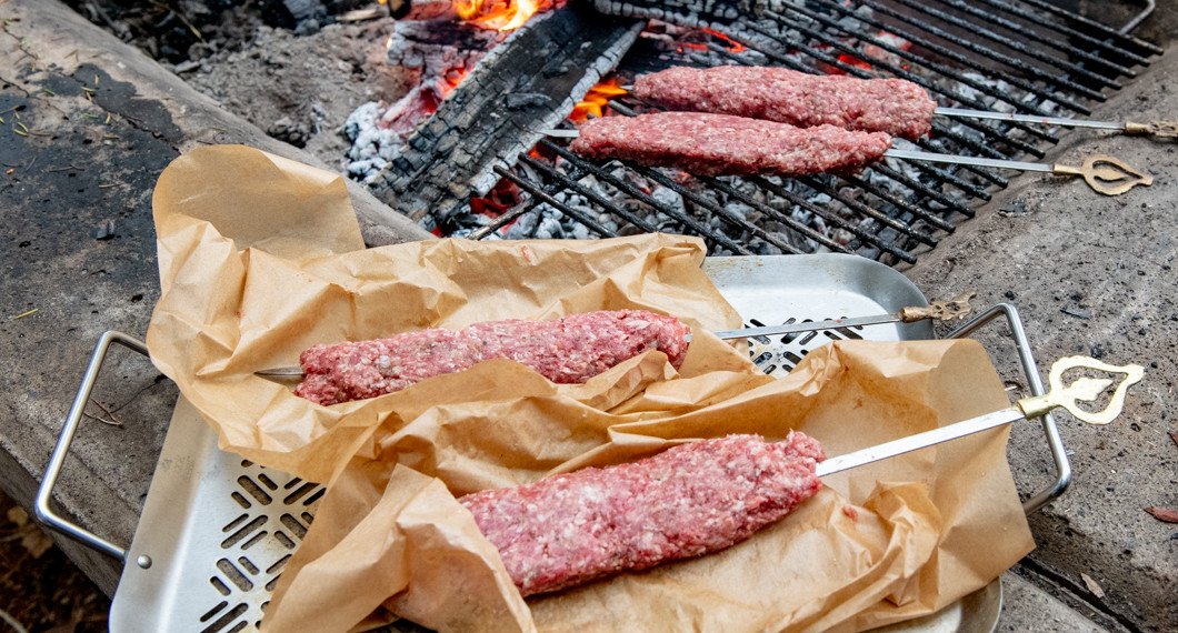 Cevapcici i bakplåtspapper på grillen
