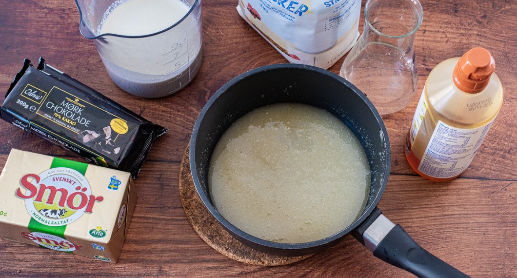 Ingredienser till chokladkolaglasyren: smör, 70% choklad, grädde, socker, vatten och sirap. 