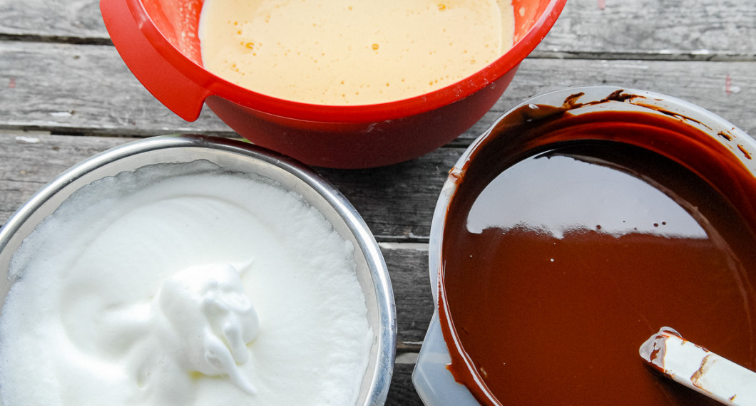 Förbered delarna till chokladmoussen: vispad äggvita, vispad äggula samt smält choklad blandad med smör och honung. 