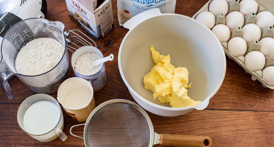 Ingredienser till chokladtårtbotten: mjölk, vetemjöl, bakpulver, vaniljsocker, kakao, socker, smör och ägg. 