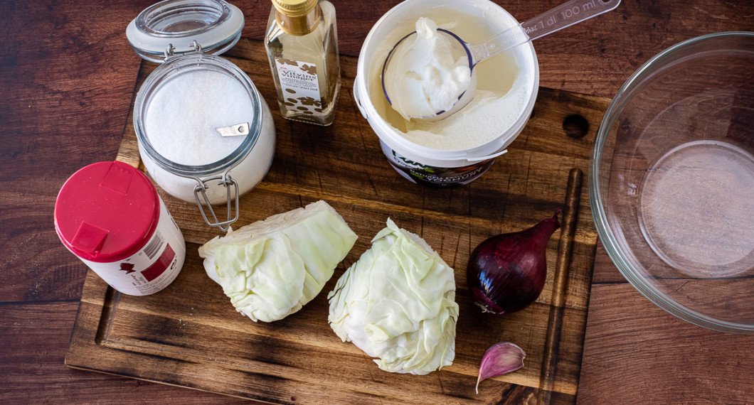 Du behöver salt, socker, vitvinsvinäger, matyoghurt, vitkål, rödlök och vitlök. 