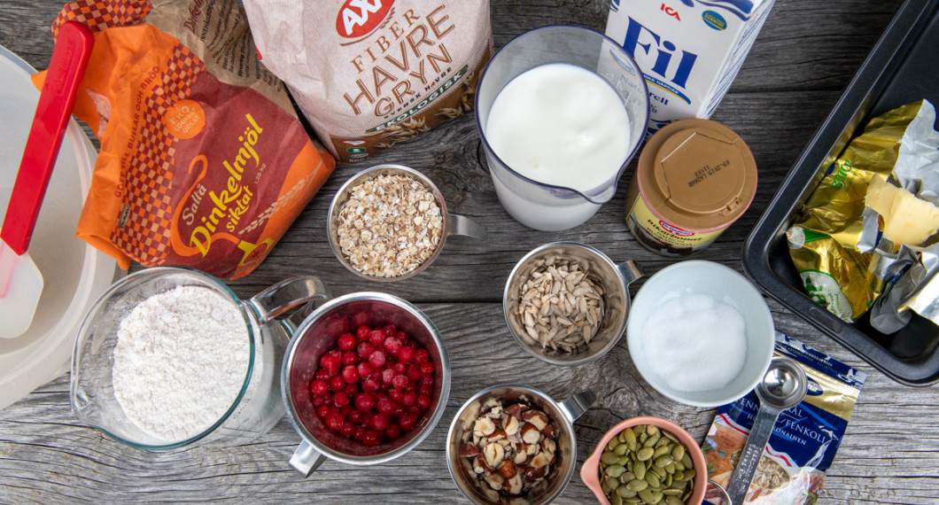 Ingredienser till bröden: siktat dinkelmjöl, frysta lingon, havregryn, hackade hasselnötter, solrosfrön, filmjölk, bikarbonat, pumpafrön, fänkål och salt.  