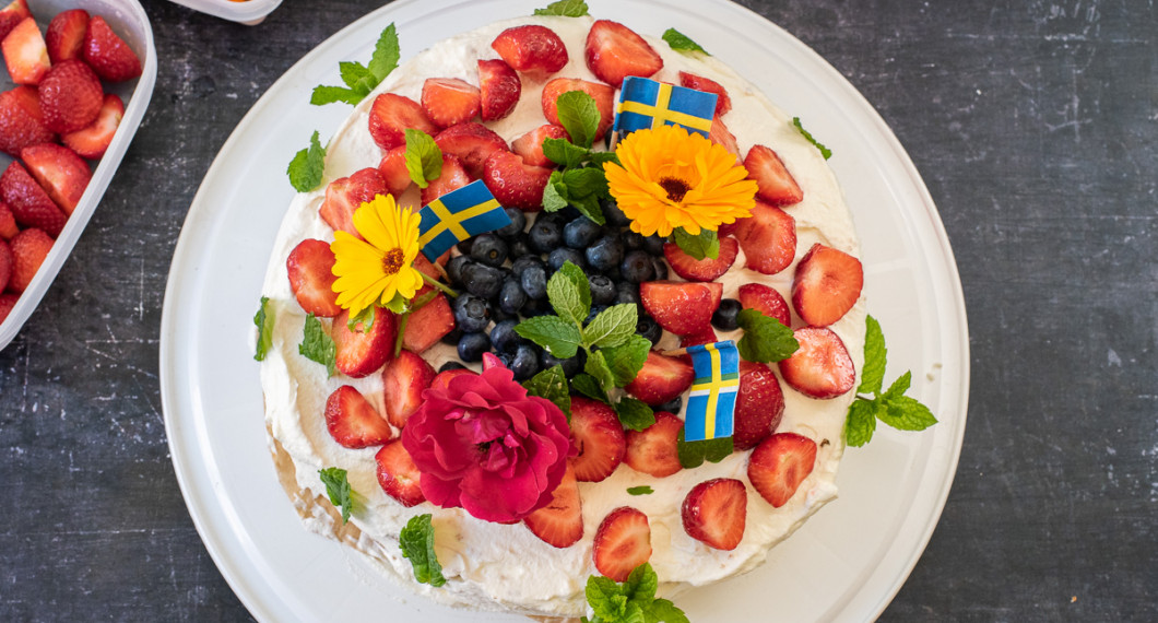 En gräddtårta som är enkel att göra med färdiga tårtbottnar fyllda med sylt och vaniljkräm toppad med grädde och bär, citronmeliss samt blommor. 
