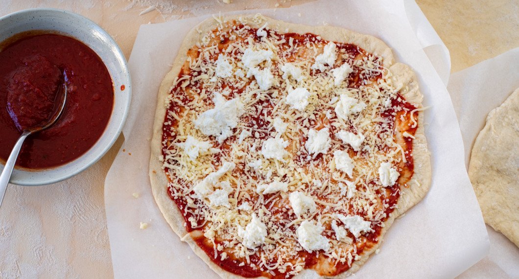 Lägg först på pizzasås, sedan ost och valfria toppings. 