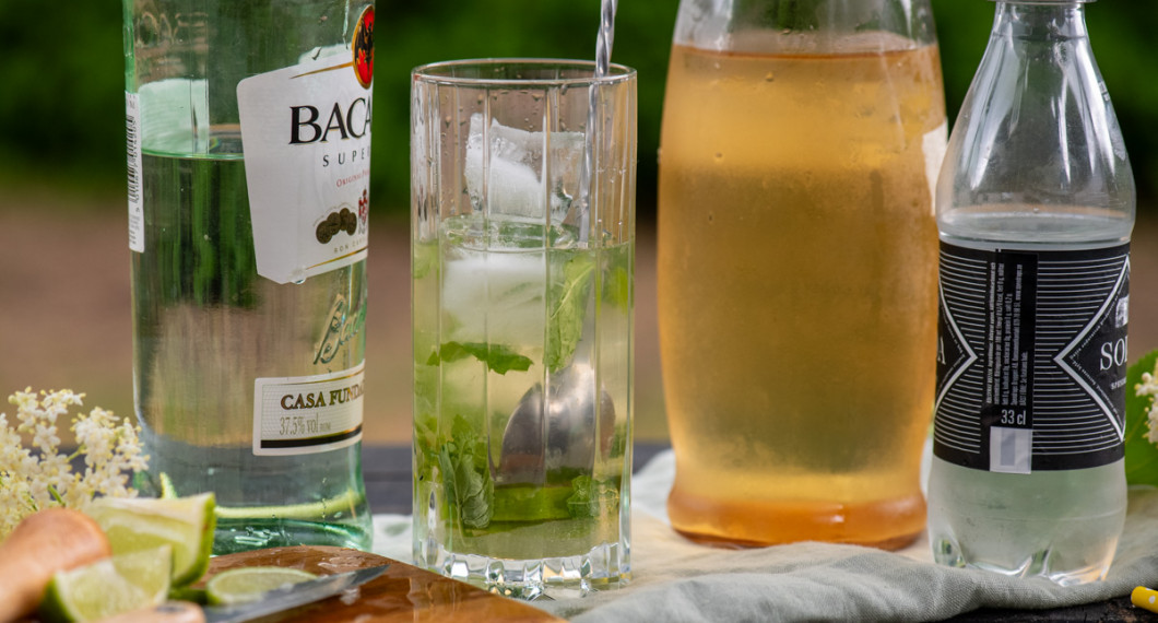 Fyll på med rom och rör om. Tillsätt is och toppa med sodavatten. 