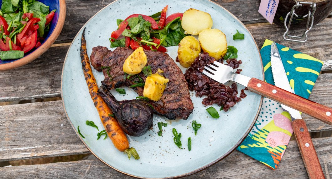 Grillad ryggbiff med tillbehör på tallrik