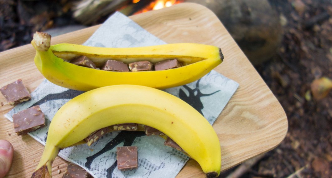 Skär ett snitt i bananerna - dock ej ända genom - och tryck in chokladbitar. 