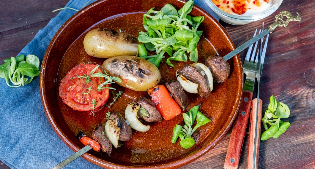 Grillad potatis serverad som tillbehör till grillspett på rostas eller annat kött. 