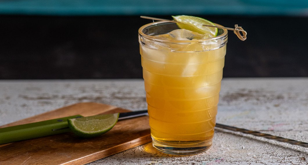 Mät upp och blanda drinken direkt i glaset. Garnera med en klyfta lime. 