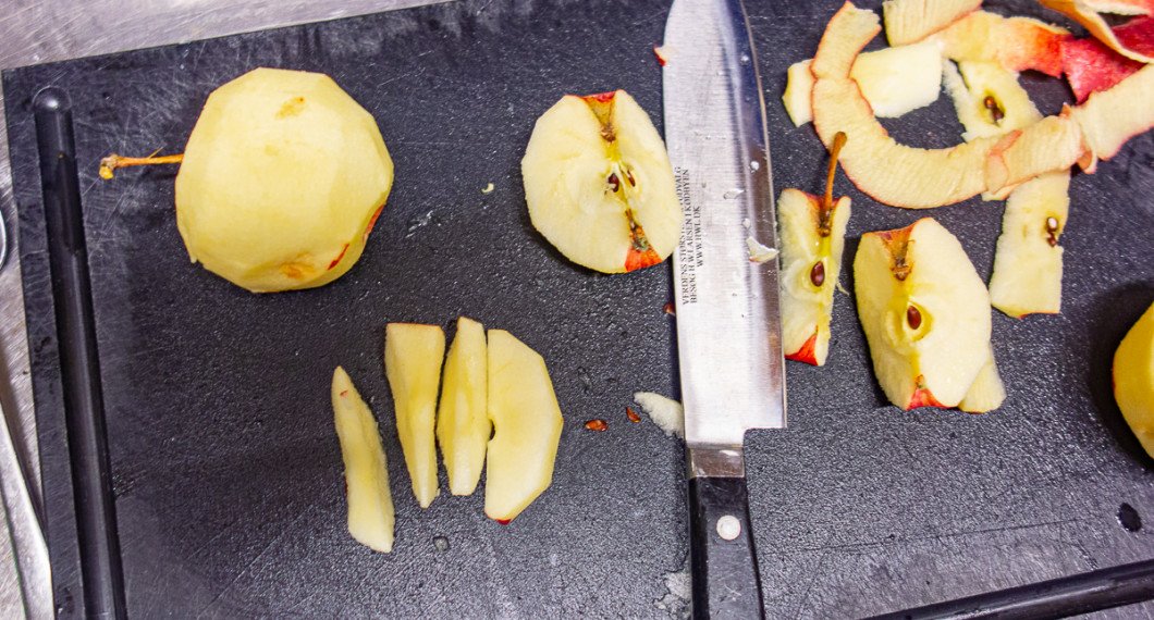 Skala och skär äpplen i klyftor. 