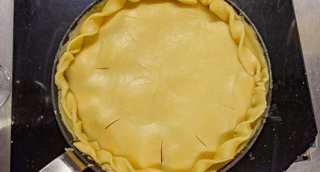 Äpplena täcks med en rundel deg och så kan man ta snurrade degremsor till kanterna som garnering. Gör vidare några hål i locket så ångan från äpplena kan pysa ut. 