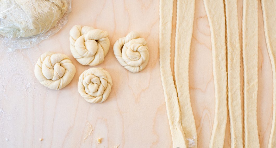 Tvinna remsorna och rulla ihop dem till snurror. Vik in den sista biten under bullen. 