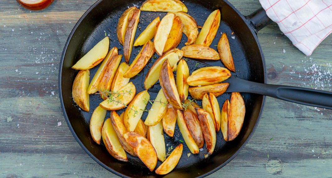 Rostade klyftor av potatis i panna