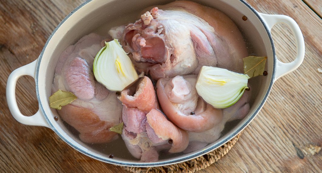 En gryta med fläsklägg redo att kokas. 