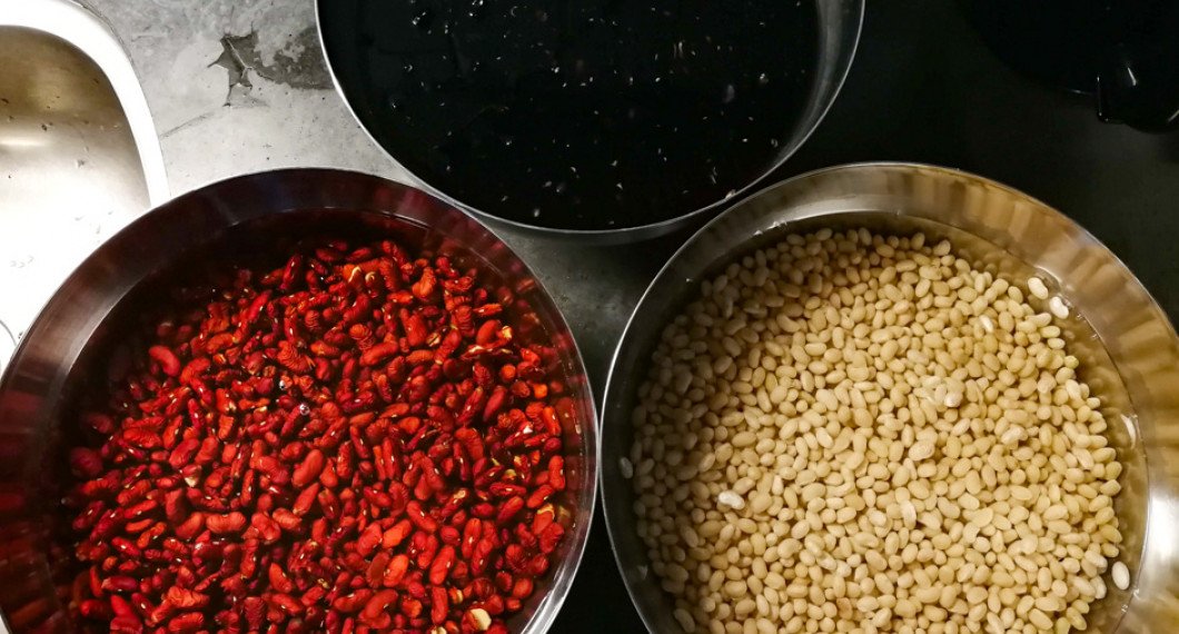 Blötlagda svarta bönor, små vita bönor och adzukibönor i skålar. 