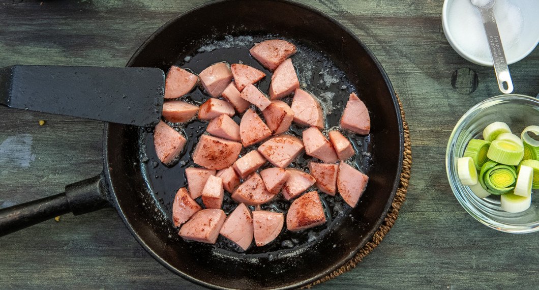 Bryn tärnad korv som ex. falukorv i smör så den får lite färg i smör i en stekpanna. 