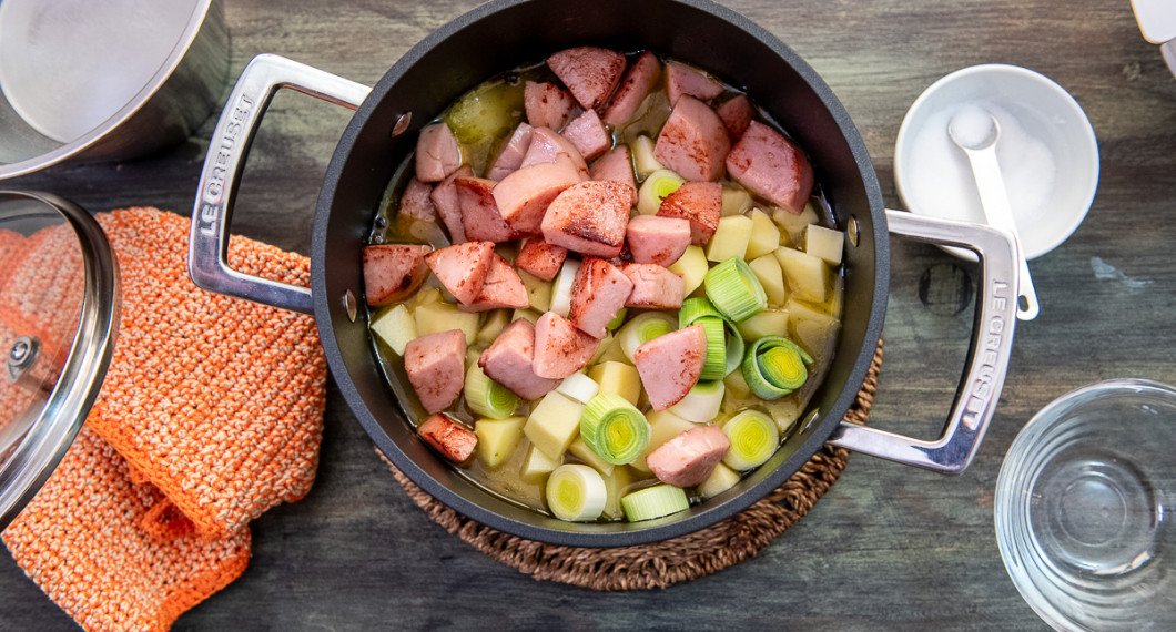 Lägg i tärnad skalad potatis, purjolök samt korv i soppan. Har du fryst persilja så tillsätt även den. 