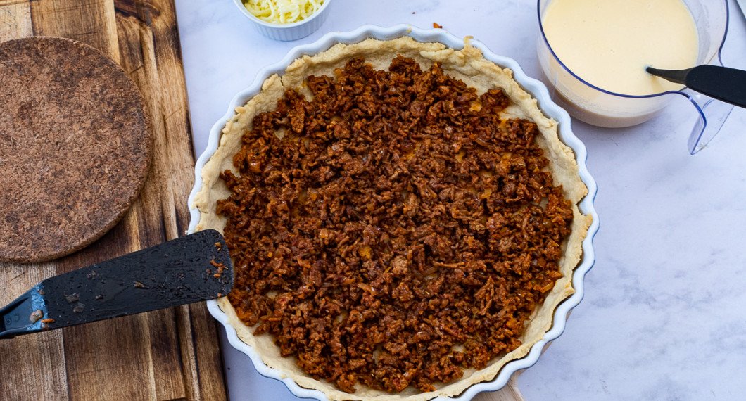 Fördela köttfärsen i botten på pajskalet. 