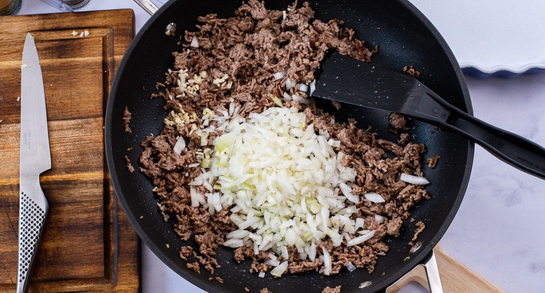 Bryn köttfärsen i olivolja samt tillsätt hackad lök och vitlök. Stek 5 minuter till. 
