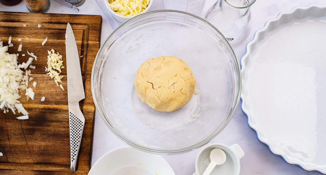 Börja med att göra pajdegen av mjöl, smör, lite vatten och salt. Låt vila i kylen i 20 minuter. 