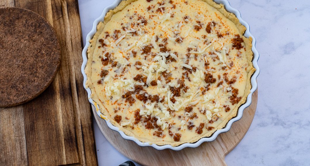 Fördela äggstanningen över köttfärsen i pajskalet. Strö över resten av osten. 