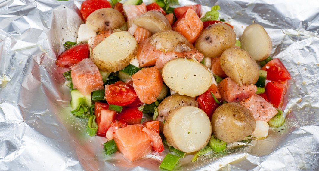 Lägg tärnad rå lax, kokt potatis samt alla ingredienser på ett folieark och vik ihop till ett paket. 
