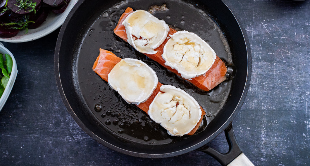 Stek en sida på laxen i en het panna och toppa sedan med getost och honung.