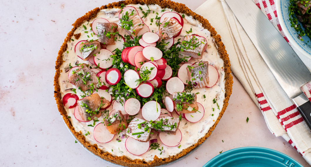 Du kan garnera tårtan på valfritt vis. Hackad dill och rädisor är fint. Jag la tre skivor rädisa på varje tänkt portion. Räknade 10 portioner. Sedan en liten bit matjessill på rädisorna. Vidare hackad dill, gräslök och rödlök i mitten och lite på varje bit matjessill. 