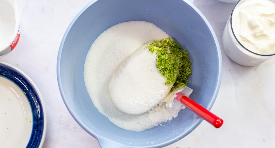 Mät upp färskost, socker, vaniljsocker och limeskal i en bunke. 