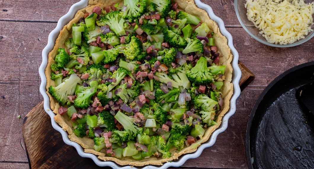 Fördela bacon och broccoli i pajskalet. 