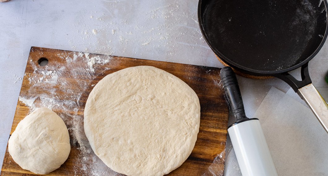 Kavla och knåda ut två pizzabottnar i storlek som den panna du tänkt grädda i - förslagsvis 24-26 cm diameter. 