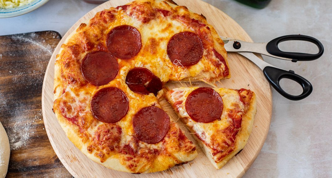 Ta ur pizzan ur panna och servera varm i slicar du klipper med sax eller skär med kniv. 